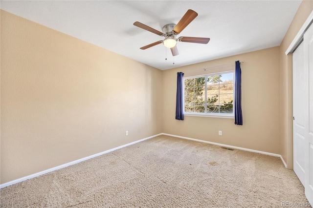 carpeted spare room featuring ceiling fan