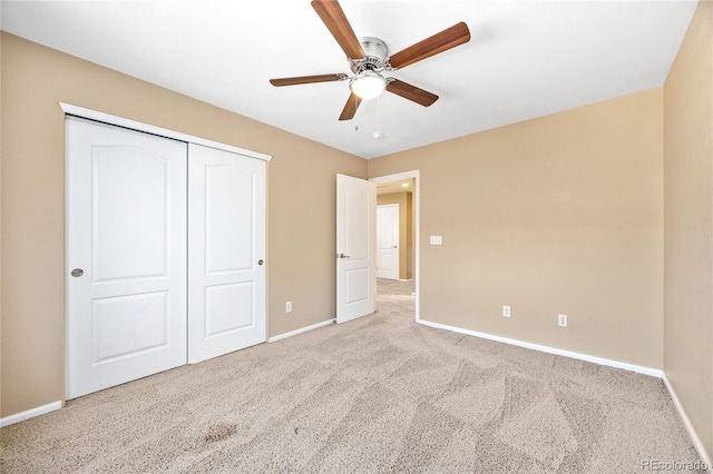 unfurnished bedroom with ceiling fan, light carpet, and a closet