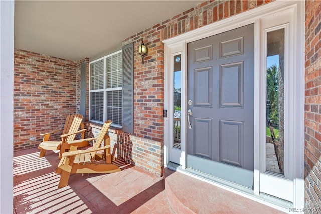 view of exterior entry featuring covered porch