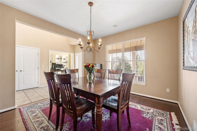 dining area featuring light hardwood / wood-style flooring and an inviting chandelier