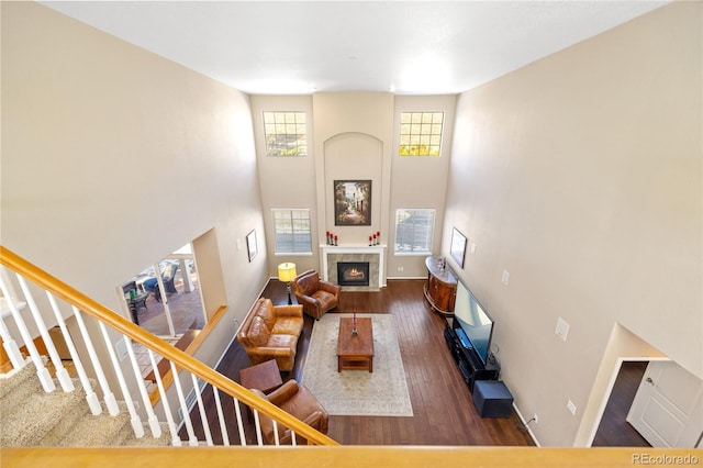 living room with dark wood-type flooring and a high ceiling