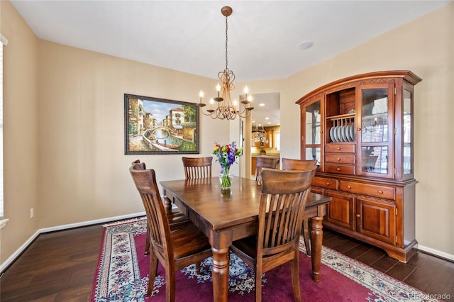 dining space with dark hardwood / wood-style floors and a notable chandelier