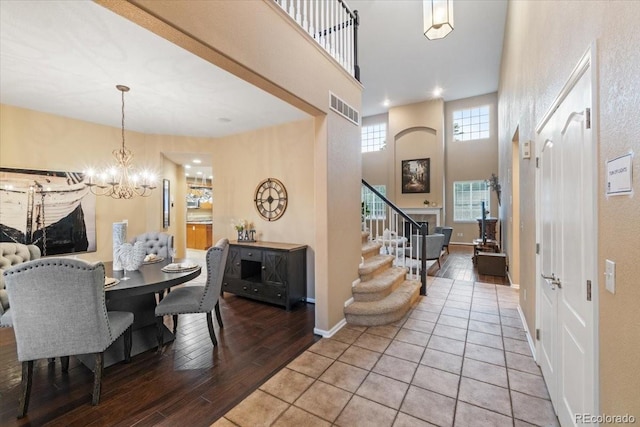6987 Esperanza Dr, Castle Pines, CO 80108 - dining space featuring a chandelier, wood finished floors, stairway, and a towering ceiling