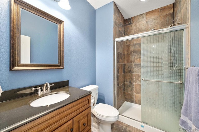 6987 Esperanza Dr, Castle Pines, CO 80108 - bathroom with a stall shower, toilet, vanity, a textured wall, and tile patterned floors