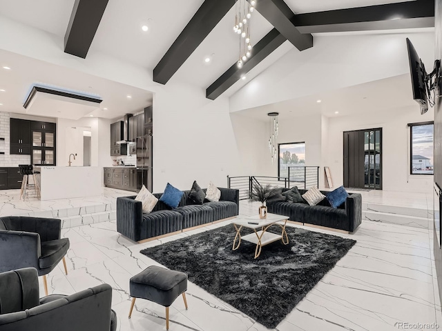 living room with beamed ceiling, a chandelier, sink, and high vaulted ceiling