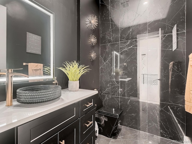 bathroom with a tile shower and vanity