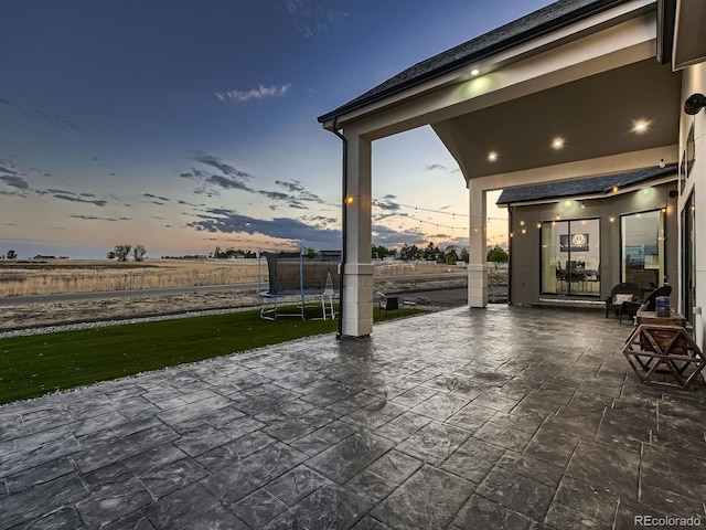 patio terrace at dusk featuring a trampoline