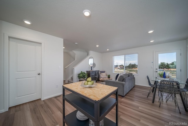 living area featuring recessed lighting, stairway, baseboards, and wood finished floors