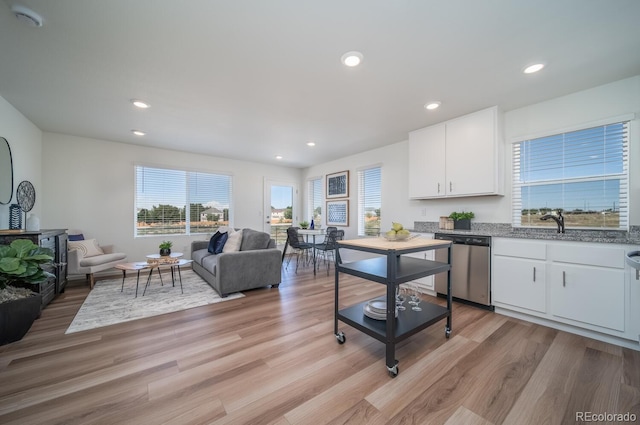 kitchen featuring open floor plan, dishwasher, recessed lighting, light wood-style flooring, and white cabinetry