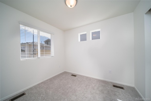 carpeted empty room with visible vents and baseboards