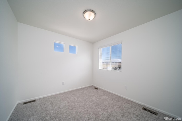 carpeted empty room with visible vents and baseboards