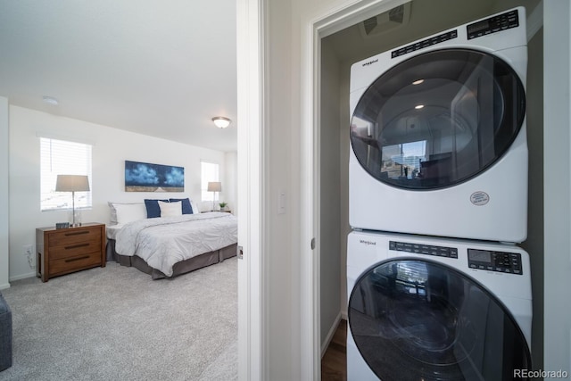 laundry room with carpet floors, laundry area, baseboards, and stacked washer and dryer