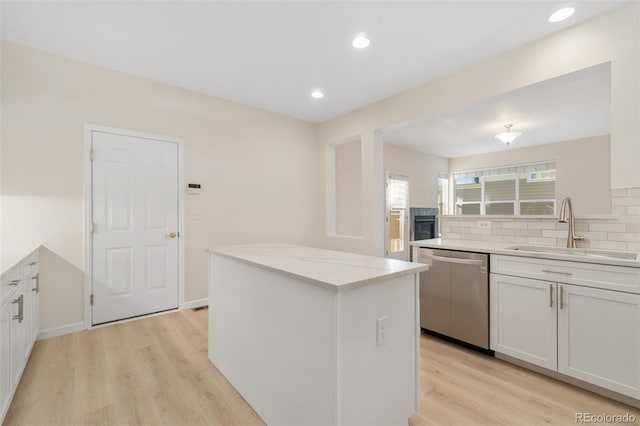 kitchen featuring white cabinets, sink, a center island, and stainless steel dishwasher