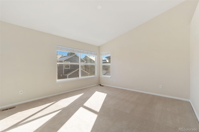 carpeted empty room featuring vaulted ceiling