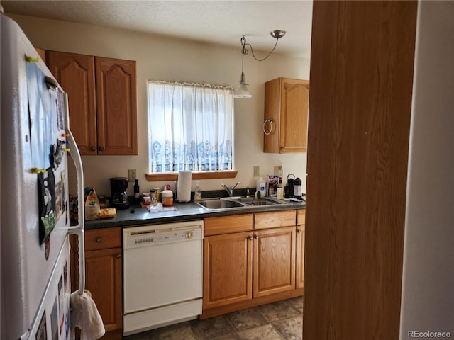 kitchen with pendant lighting, white appliances, and sink