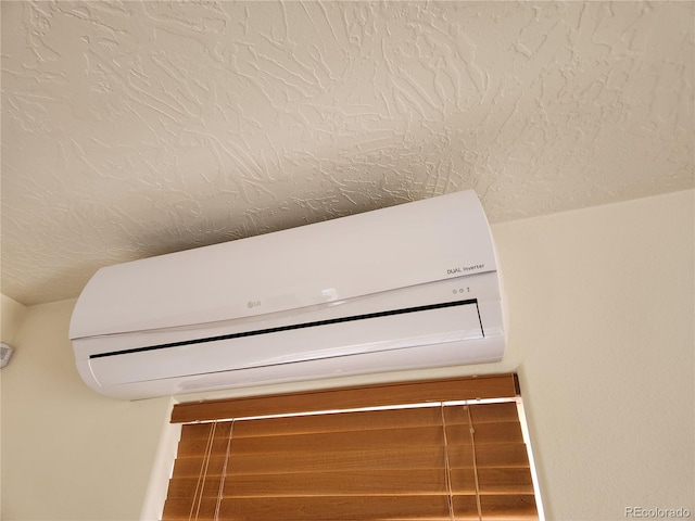 details with a textured ceiling and a wall unit AC