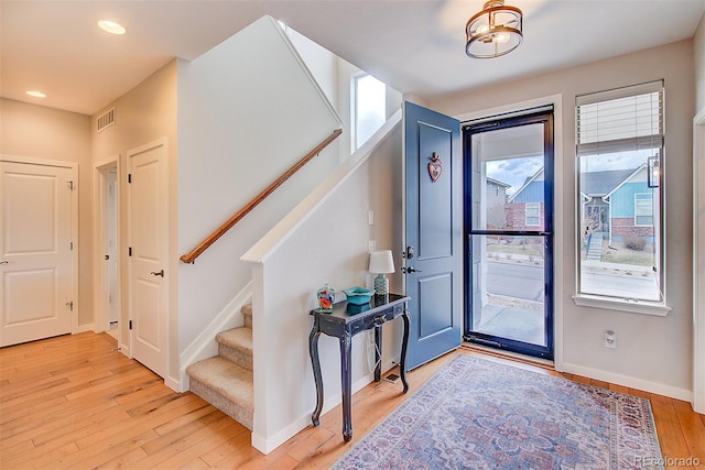 entrance foyer featuring light wood finished floors, recessed lighting, visible vents, stairway, and baseboards