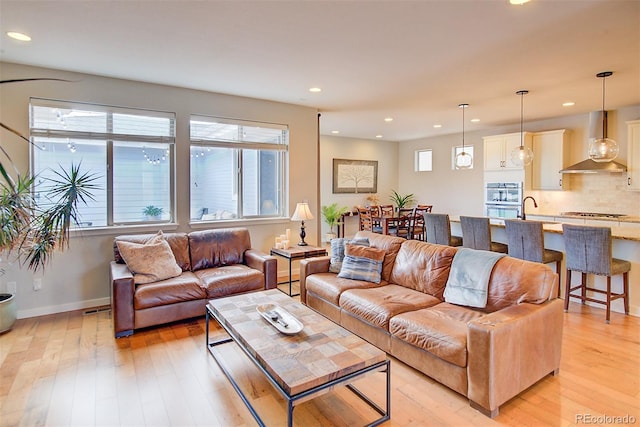 living area with baseboards, recessed lighting, visible vents, and light wood-style floors