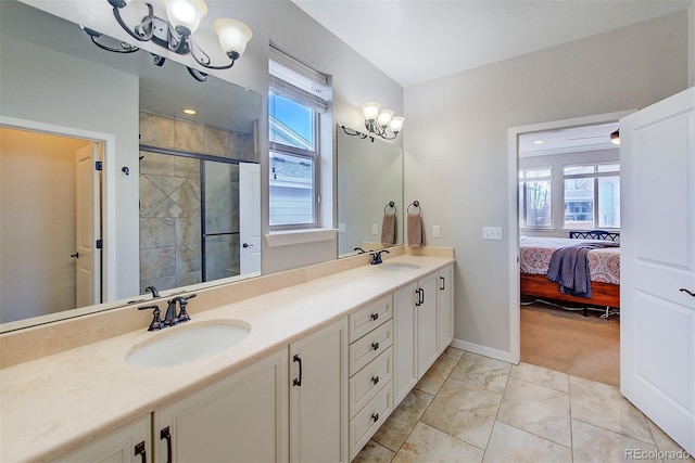 ensuite bathroom featuring double vanity, a stall shower, a chandelier, and a sink