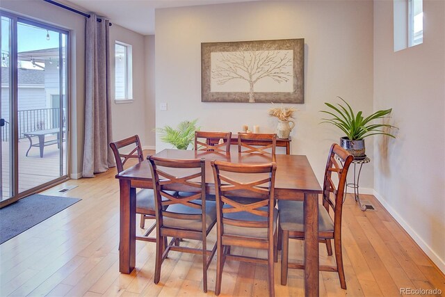 dining area with light wood-style floors, visible vents, and baseboards