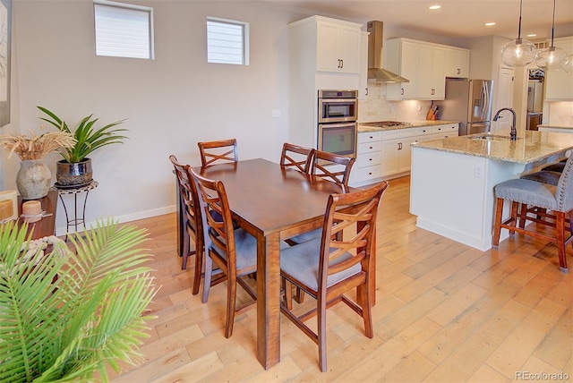 dining space featuring recessed lighting, light wood-style flooring, and baseboards