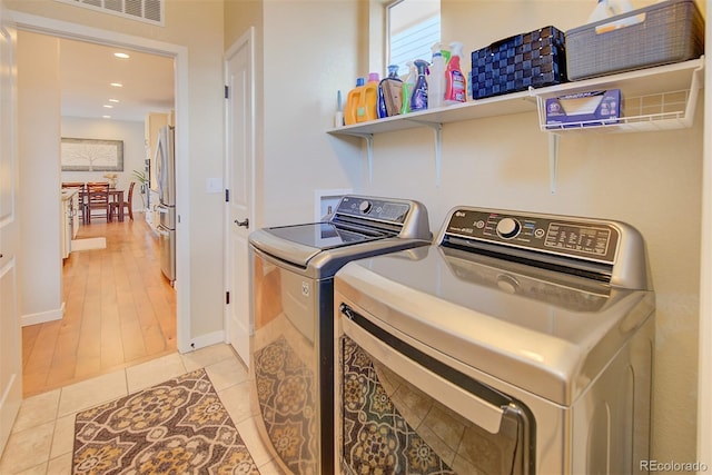 clothes washing area featuring recessed lighting, visible vents, washing machine and dryer, light tile patterned flooring, and laundry area