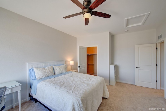 bedroom featuring light carpet, attic access, visible vents, baseboards, and a ceiling fan