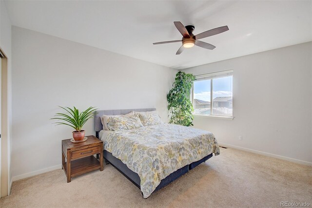 bedroom with light colored carpet, ceiling fan, and baseboards