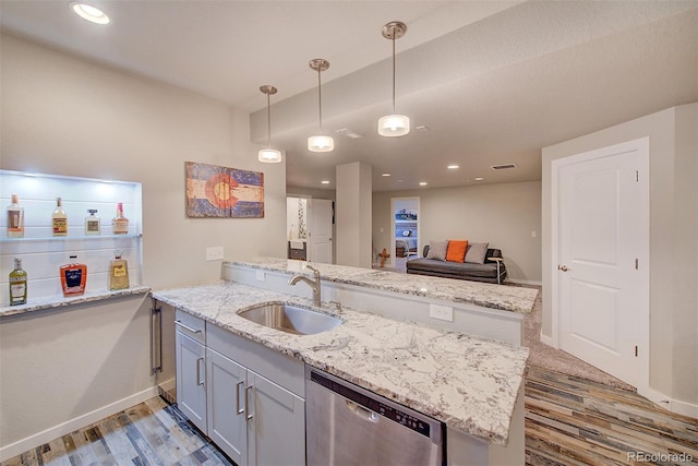 kitchen featuring light wood-type flooring, stainless steel dishwasher, baseboards, and a sink