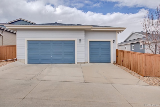 garage with driveway and fence