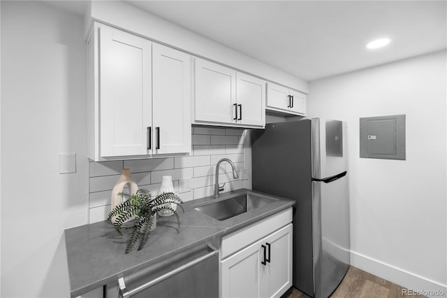 kitchen featuring electric panel, sink, and white cabinets