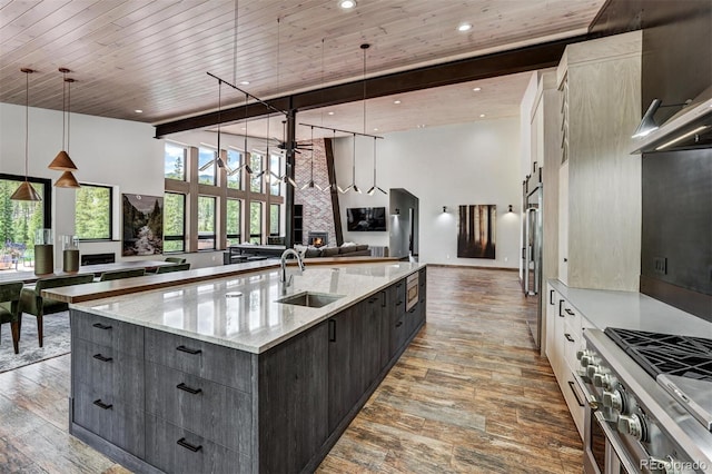 133 Adams Way, Breckenridge, CO 80424 - kitchen featuring a sink, stainless steel stove, open floor plan, a towering ceiling, and hardwood / wood-style flooring
