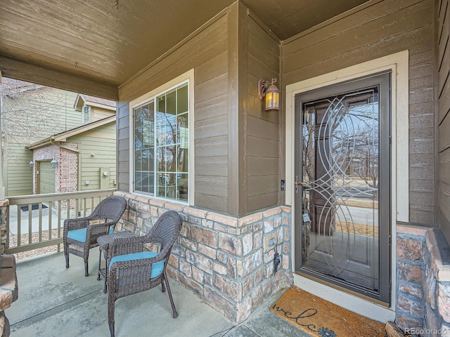 doorway to property with brick siding and a porch