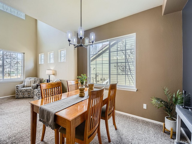 dining room with a notable chandelier, carpet flooring, baseboards, and visible vents