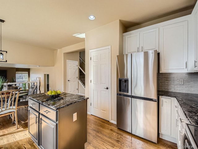 kitchen with white cabinetry, a center island, stainless steel fridge with ice dispenser, and light wood finished floors