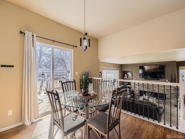 dining space with baseboards, wood finished floors, visible vents, and a healthy amount of sunlight