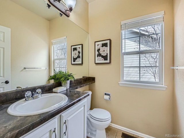 bathroom featuring vanity, baseboards, visible vents, tile patterned floors, and toilet