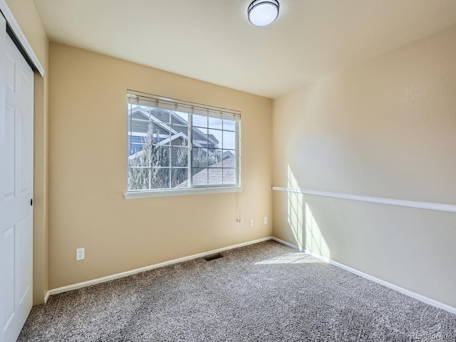 spare room featuring visible vents, baseboards, and carpet