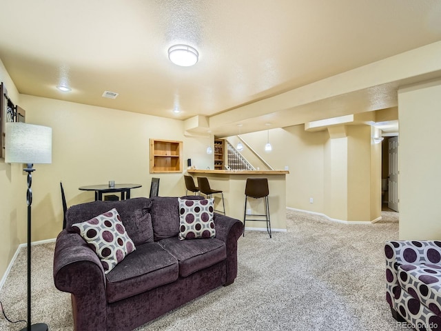 living area with visible vents, carpet floors, baseboards, and a dry bar