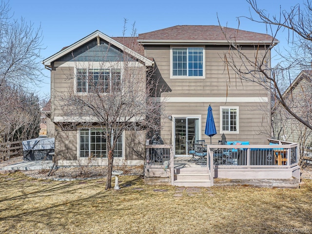 rear view of property with a lawn, a deck, and fence