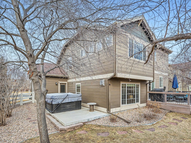 back of house featuring a patio, a hot tub, and a deck