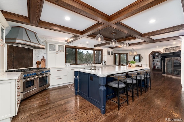 kitchen with glass insert cabinets, custom exhaust hood, range with two ovens, and dark wood finished floors