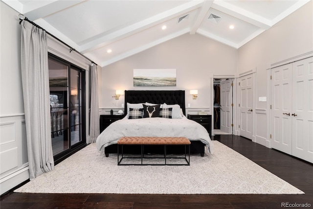 bedroom with visible vents, wainscoting, dark wood-style floors, access to outside, and a decorative wall