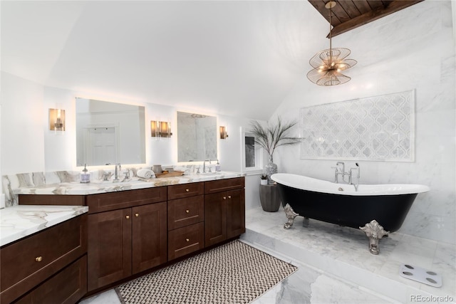 bathroom featuring a sink, vaulted ceiling, a freestanding bath, marble finish floor, and double vanity