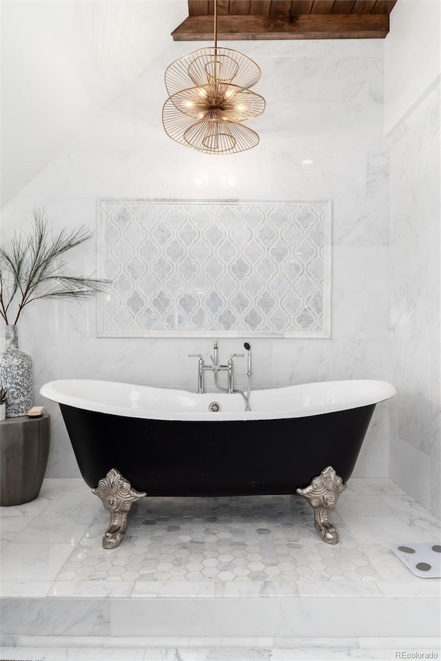 full bathroom featuring marble finish floor and a freestanding bath