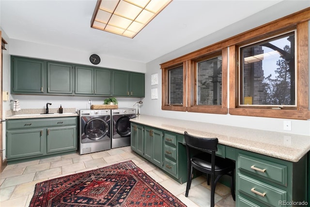 laundry room with separate washer and dryer, a sink, and cabinet space