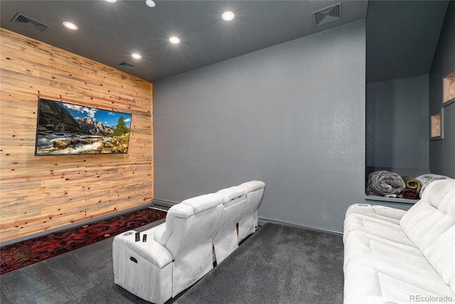 home theater room featuring dark colored carpet, wood walls, visible vents, and recessed lighting