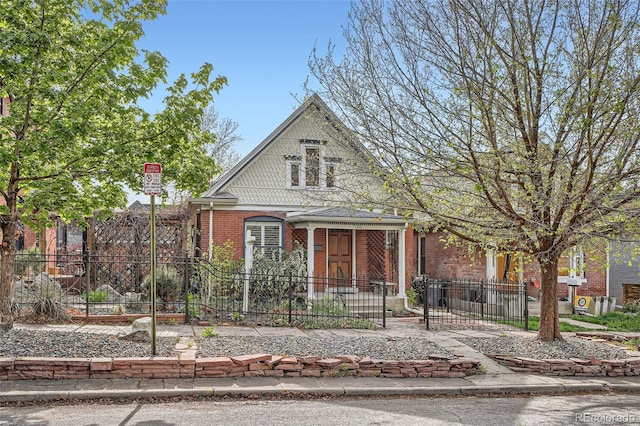 bungalow-style house with brick siding and a fenced front yard
