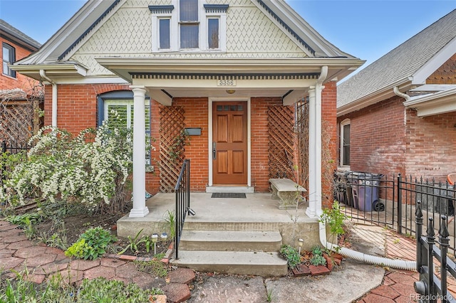 entrance to property with brick siding and fence