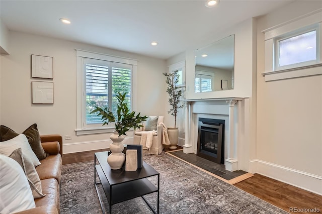 living area with recessed lighting, a fireplace with flush hearth, and a wealth of natural light